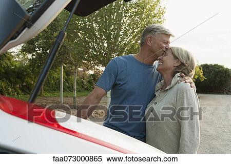 Senior couple standing beside car, man kissing woman's forehead View Large Photo Image Stock Photography - Senior couple standing beside car, man kissing woman's forehead. Fotosearch