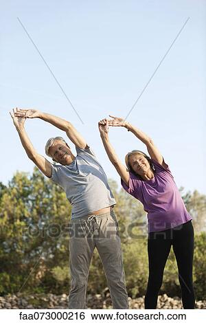 Stock Photograph - Senior couples stretching outdoors. Fotosearch