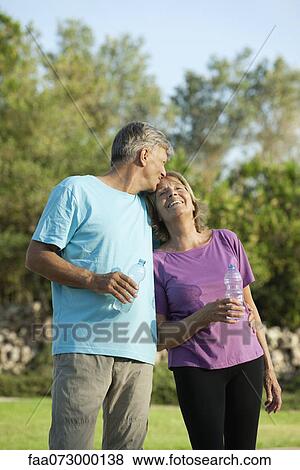 Stock Photo - Senior man kissing wife's forehead. Fotosearch