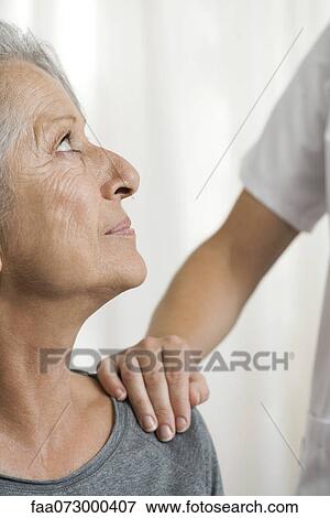 Stock Photo - Senior woman being comforted by another woman, cropped. Fotosearch