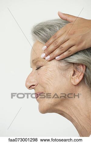Stock Photo - Senior woman having her temples massaged, cropped. Fotosearch