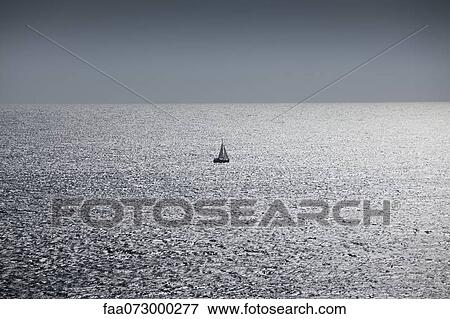 Solitary sailboat at sea View Large Photo Image Stock Photo - Solitary sailboat at sea. Fotosearch