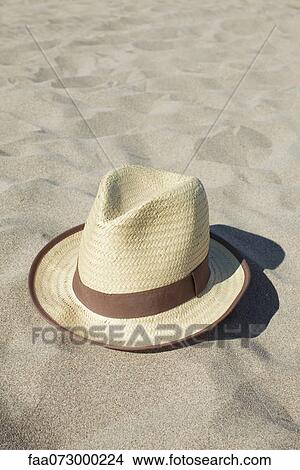 Picture - Straw hat on beach. Fotosearch
