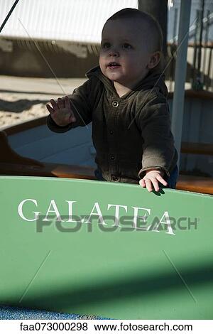 Stock Photo - Toddler playing in boat. Fotosearch