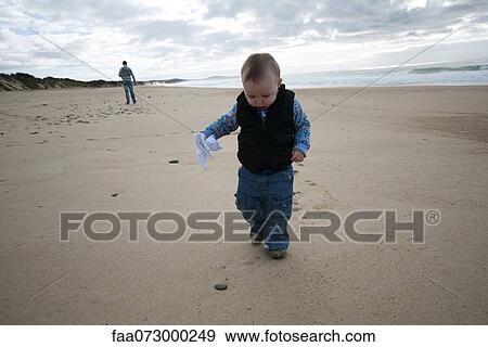 Toddler walking on beach View Large Photo Image Stock Photo - Toddler walking on beach. Fotosearch