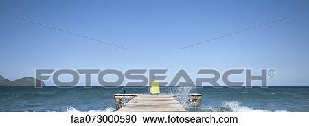 Waves crashing against dock, yellow suitcase at end of dock View Large Photo Image Stock Image - Waves crashing against dock, yellow suitcase at end of dock. Fotosearch