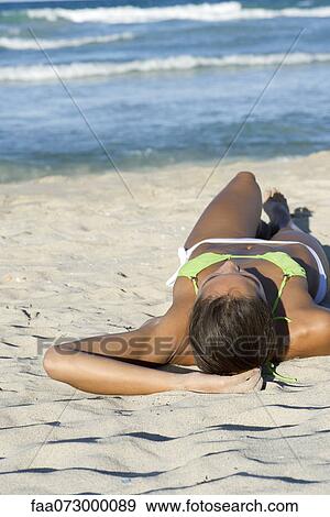 Woman in bikini lying on beach View Large Photo Image Stock Photo - Woman in bikini lying on beach. Fotosearch
