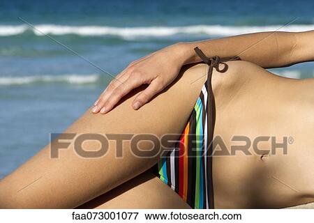 Woman in bikini lying on side, mid section View Large Photo Image Stock Photo - Woman in bikini lying on side, mid section. Fotosearch