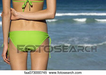 Woman in bikini standing by sea View Large Photo Image Stock Photography - Woman in bikini standing by sea. Fotosearch
