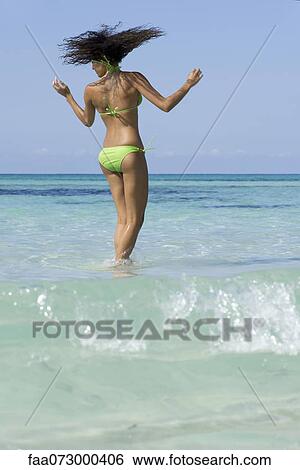 Woman in bikini standing in water, shaking head View Large Photo Image Stock Photograph - Woman in bikini standing in water, shaking head. Fotosearch