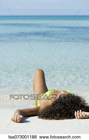 Woman in bikini sunbathing on beach View Large Photo Image Stock Photo - Woman in bikini sunbathing on beach. Fotosearch