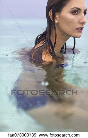 Woman in water, looking away in thought View Large Photo Image Stock Photo - Woman in water, looking away in thought. Fotosearch
