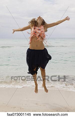 Woman jumping in midair at the beach View Large Photo Image Stock Photography - Woman jumping in midair at the beach. Fotosearch