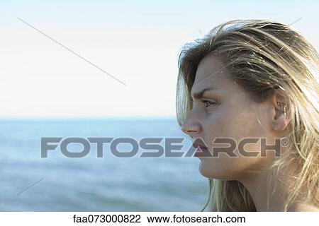 Stock Image - Woman looking at view, side view. Fotosearch