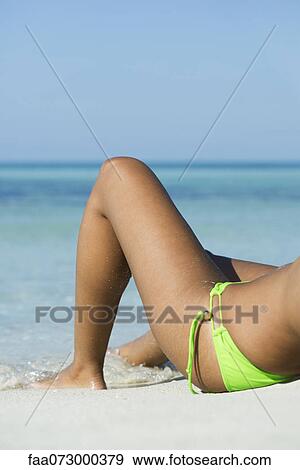 Woman lying on beach, low section View Large Photo Image Stock Photo - Woman lying on beach, low section. Fotosearch