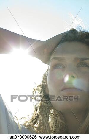 Stock Photograph - Woman outdoors, backlit, portrait. Fotosearch