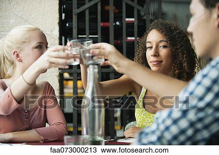 Woman raising glass with friends View Large Photo Image Stock Image - Woman raising glass with friends. Fotosearch