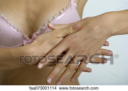 Picture - Woman rubbing hands, close-up. Fotosearch