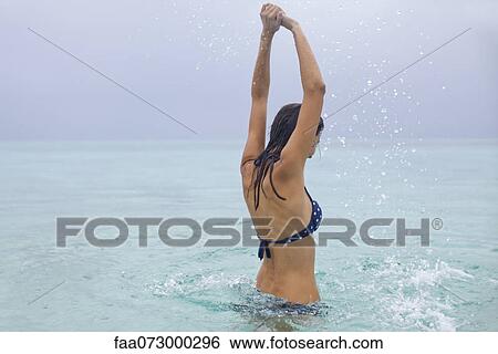 Stock Photograph - Woman splashing in water. Fotosearch