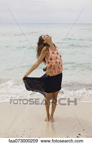 Woman standing on beach with head back and eyes closed View Large Photo Image Stock Photo - Woman standing on beach with head back and eyes closed. Fotosearch