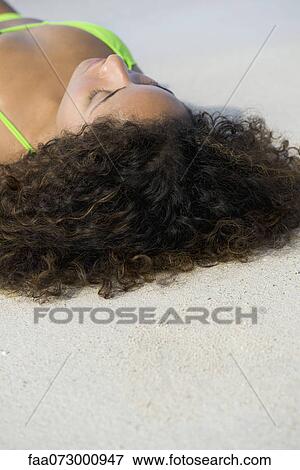 Woman sunbathing at the beach, cropped View Large Photo Image Stock Photo - Woman sunbathing at the beach, cropped. Fotosearch