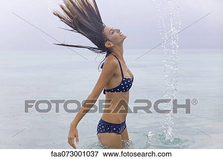 Woman tossing wet hair in water View Large Photo Image Stock Photo - Woman tossing wet hair in water. Fotosearch
