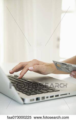 Woman using laptop computer to make an internet purchase, cropped View Large Photo Image Stock Photography - Woman using laptop computer to make an internet purchase, cropped. Fotosearch