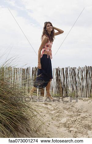 Woman walking in sand at the beach View Large Photo Image Picture - Woman walking in sand at the beach. Fotosearch