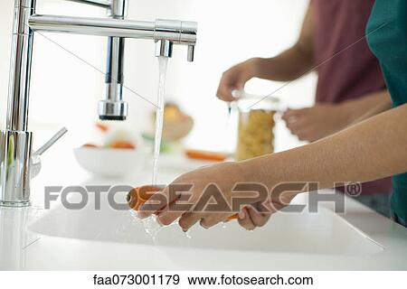 Woman washing carrot, cropped View Large Photo Image Stock Photo - Woman washing carrot, cropped. Fotosearch