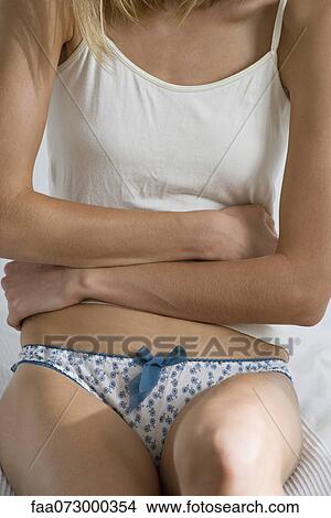 Woman with arms across abdomen, mid section View Large Photo Image Picture - Woman with arms across abdomen, mid section. Fotosearch