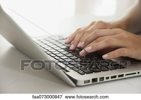 Stock Photo - Woman's hands typing on laptop computer. Fotosearch