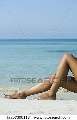 Picture - Woman's legs on beach, low section. Fotosearch