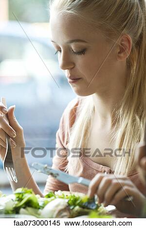 Young blond woman eating with fork and knife View Large Photo Image Stock Photography - Young blond woman eating with fork and knife. Fotosearch