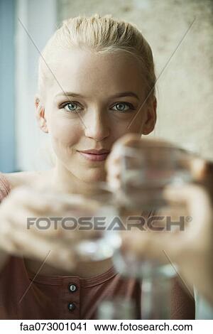Young blond woman raising glass View Large Photo Image Stock Image - Young blond woman raising glass. Fotosearch