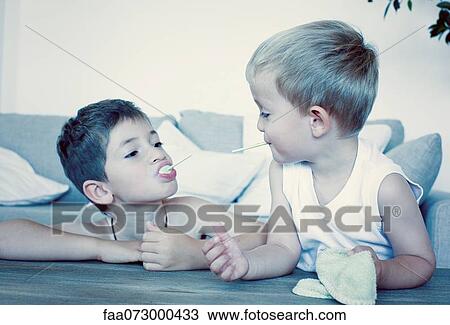 Young brothers eating lollipops View Large Photo Image Stock Image - Young brothers eating lollipops. Fotosearch