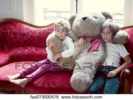 Young brothers embracing large teddy bear, portrait View Large Photo Image Stock Photograph - Young brothers embracing large teddy bear, portrait. Fotosearch