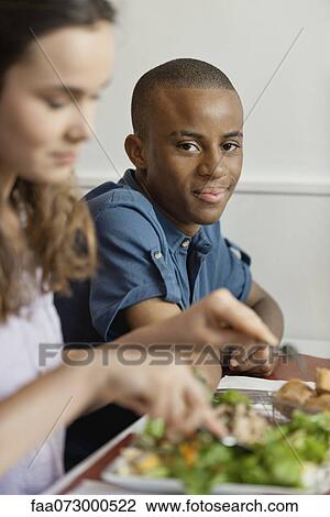 Stock Image - Young man in restaurant. Fotosearch