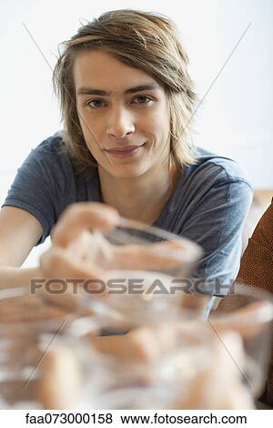 Stock Photo - Young man raising glass. Fotosearch