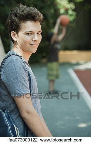 Stock Image - Young man smirking, portrait. Fotosearch