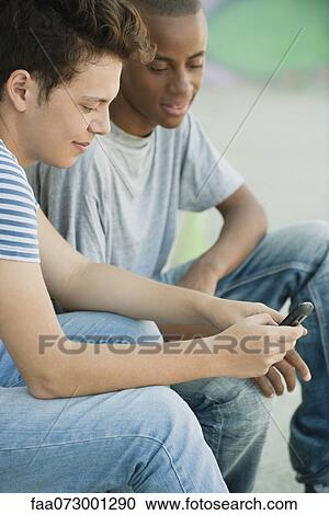 Stock Image - Young man text messaging. Fotosearch