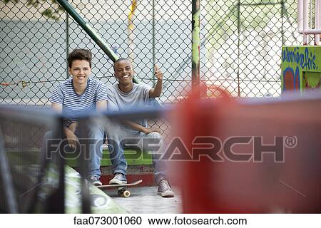 Young men hanging out in skateboard park View Large Photo Image Stock Image - Young men hanging out in skateboard park. Fotosearch