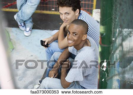 Stock Image - Young men hanging out together. Fotosearch