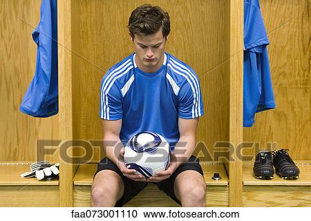 Young soccer player looking down at soccer in hands, portrait View Large Photo Image Stock Image - Young soccer player looking down at soccer in hands, portrait. Fotosearch