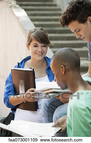 Stock Photo - Young woman discussing homework with friends. Fotosearch
