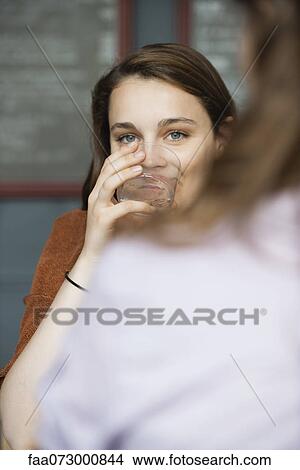 Picture - Young woman drinking from glass. Fotosearch