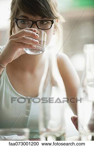 Young woman drinking from glass View Large Photo Image Stock Image - Young woman drinking from glass. Fotosearch