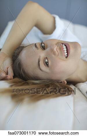 Young woman lying down, portrait View Large Photo Image Stock Image - Young woman lying down, portrait. Fotosearch