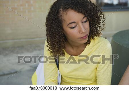 Young woman sitting outdoors View Large Photo Image Stock Photo - Young woman sitting outdoors. Fotosearch