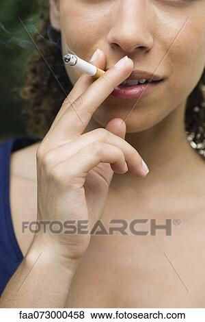 Young woman smoking cigarette, cropped View Large Photo Image Stock Photo - Young woman smoking cigarette, cropped. Fotosearch