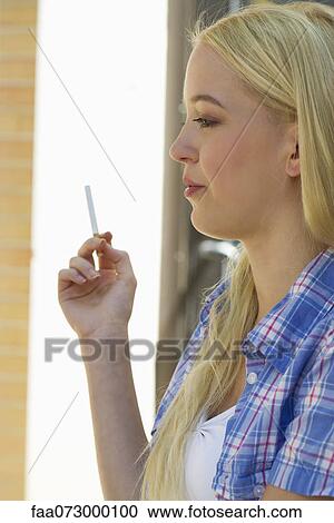 Young woman smoking cigarette View Large Photo Image Stock Image - Young woman smoking cigarette. Fotosearch